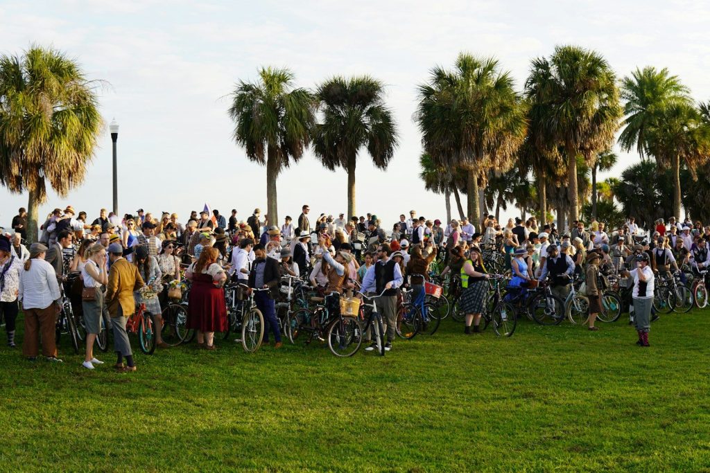 people riding bicycles on green grass field during daytime
